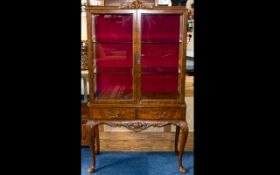 A Walnut Glazed Display Cabinet Two door glazed cabinet above two frieze drawers, carved apron and