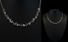 An 18ct White Gold Collarette Necklace Set With Swiss Blue Topaz Rhodolite And Iolite Wonderful and