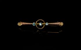 A 9ct Gold Antique Stone Set Bar Brooch with three aqua coloured stones to the centre.