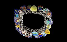 A Vintage Silver Curb Bracelet Loaded with enamel on silver shield medallions of town crests, over