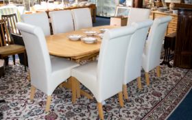 A Contemporary Beech Wood Extending Dining Table And Chairs The table of oval form,