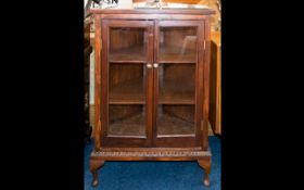 A Glazed Display Cabinet raised on Queen Anne legs with glazed front doors and sides. With