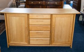 A Contemporary Beech Wood Sideboard Comprising a central bank of five graduating drawers between