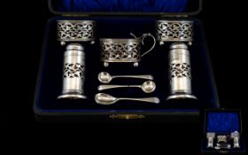 A Five Piece Silver Condiment Set In Fitted Case Plain pierced bodies, raised on cannonball feet,