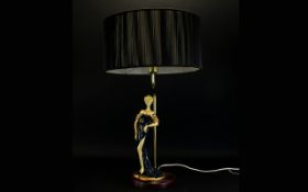 Decorative Table Lamp with a figure of a lady surmounted to a circular mahogany effect base,