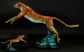 A Large Coldpainted Bronze In The form Of A Leaping Cheetah Raised on organic form black marble