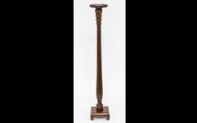 A Victorian Mahogany Torchere Turned standard raised on a square base with bracket feet.