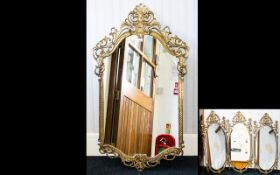 A Set Of Four Matching Brass Framed Wall Mirrors The cast brass in Empire style.