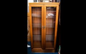 Glazed Display Cabinet Two door cabinet with glazed doors and brass pulls. Three glazed shelves to