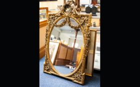 A Large Gilt Rococo Style Mirror Housed in ornately decorated frame, the top adorned with cherubs,