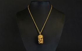 An Ethnic Male Head Pendant on a Gold Colour Chain