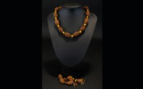 A Late 19th Century Carved Hediau Fruit Nut Bead Necklace Each reticulated, oval bead profusely