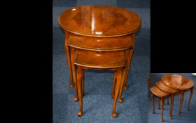 A Nest of Three Walnut Tables, oval topped, cabriole legs. Height 21 inches.