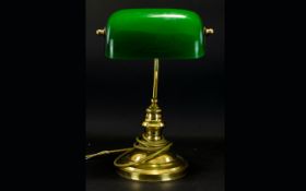 Bankers Lamp Comprising circular brass tone bass with traditional bottle green hinged glass shade.