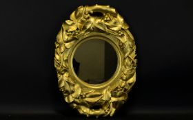 A 19th Century Carved Wood Gesso Mirror The ovoid frame in the form of foliate garland comprising