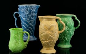 A Collection Of Four Art Deco Period Wade Moulded Water Jugs Of various forms to include sky blue