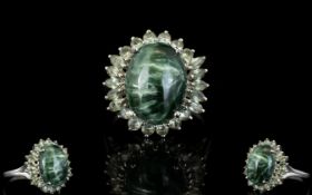 Siberian Seraphinite and Green Sapphire Ring, a 7ct oval cut cabochon of seraphinite,