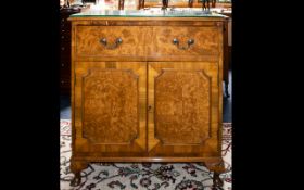 A Walnut Side Cabinet Single drawer above storage base, raised on short cabriole feet.