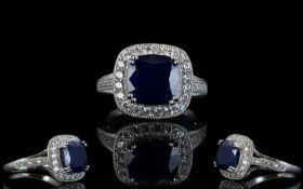 Sapphire and Natural White Zircon Ring, with ruby accents; a 6.5ct cushion cut blue sapphire