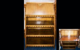 A Blonde Wood Writing Bureau of small proportions with two lower shelves and fall front section