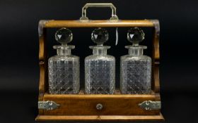 Early 20th Century Three Decanter Tantalus With Gothic mounts and strap work, complete with key,