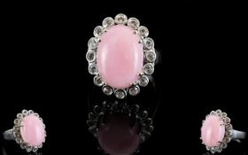 Pink Opal and White Topaz Halo Ring, a 9ct oval cut cabochon of pink opal framed with .