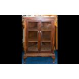 A Glazed Display Cabinet raised on Queen Anne legs with glazed front doors and sides. With