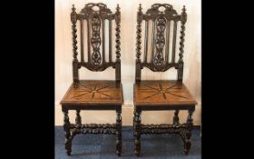 A Pair of Rustic Ebonised Oak Hall Chairs.