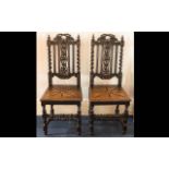 A Pair of Rustic Ebonised Oak Hall Chairs.