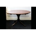 Edwardian tilt top table raised on quatrefoil base with brass castors. Oval top with warm, ages,