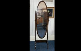 An Early 20thC Free Standing Bedroom Mahogany Framed Cheval Mirror of elegant oval form. Finial