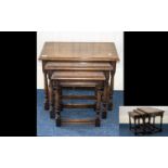 A Nest of Tables finished in varnished dark oak, of rectangular form, turned legs with rectangular