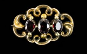 A Victorian Garnet Set Brooch Of typical form set in oval filigree yellow metal mount,