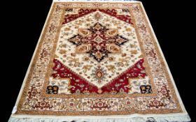 A Large Woven Silk Heriz Carpet Finley woven rug on beige ground with intricate scrolling floral