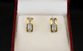 14ct Gold Stud Earrings Set with four round cut diamonds and a princess cut Aquamarine.