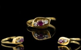 18ct Gold - Attractive Ruby and Diamond 3 Stone Dress Ring. The Central Ruby Flanked by Two Small
