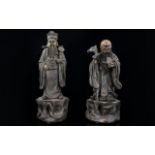 A Pair Of Oriental Figures Each in the form of Emperors, height 7 inches.