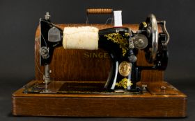 Antique Singer Sewing Machine complete with domed wood carry case.