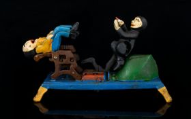 A Cast Iron Moneybank Painted bank in the form of an articulated dentists chair with figures