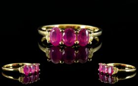 Ruby and White Topaz Ring, a trio of oval cut rubies, accented with small, round white topaz,