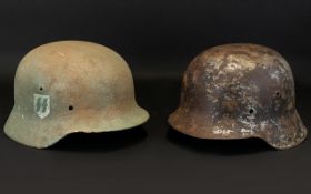 Two German Second World War Helmets. SS Badge To Side And To The Opposite A Nazi Swastika.