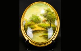 A Painted Plaster Plaque oval form convex plaque depicting a rural landscape, gilt trim, Unsigned.