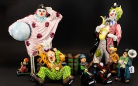 A collection of seven decorative Clown Figures to include two large standing clowns, a seated