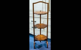 An Early 20th Century 3-tier Cake Stand of typical form with arched feet and folding trays.