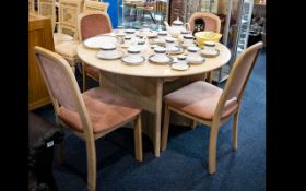 A Modern limed Oak Circular Contemporary Table With Four Chairs Upholstered In Peach Fabric.