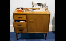 A Vintage Singer Sewing Machine In Original Mid-Century Cabinet with four drawers with integral