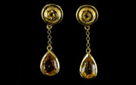 Citrine Pair of Drop Earrings, each earring comprising a bezel set, pear cut citrine, suspended,