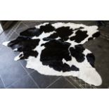 Large Cowhide Rug Of traditional form in monochromatic hide, some areas of wear/staining in places.