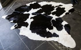 Large Cowhide Rug Of traditional form in monochromatic hide, some areas of wear/staining in places.