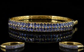 Tanzanite Double Row Hinged Bangle, two rows of oval cut tanzanites, totalling 9cts,